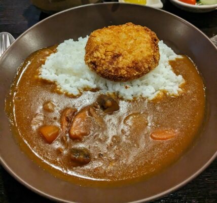 A plate of Japanese curry rice with unexpected salad toppings at a Tokyo restaurant