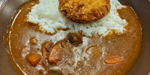 A plate of Japanese curry rice with unexpected salad toppings at a Tokyo restaurant