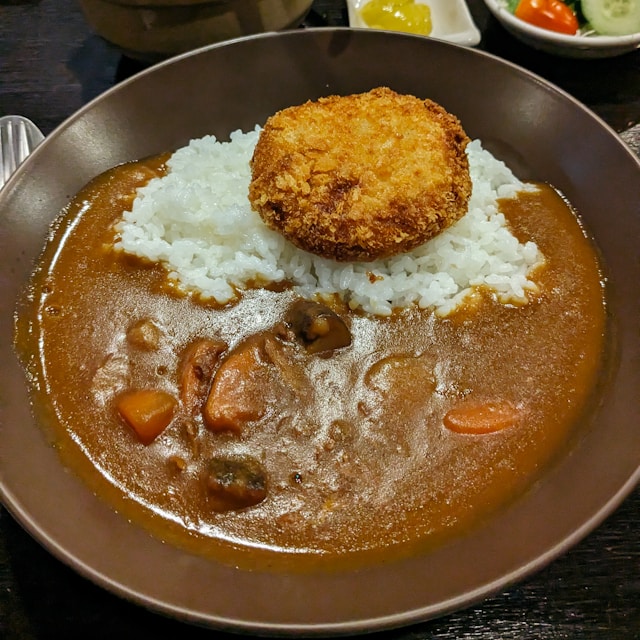 A plate of Japanese curry rice with unexpected salad toppings at a Tokyo restaurant